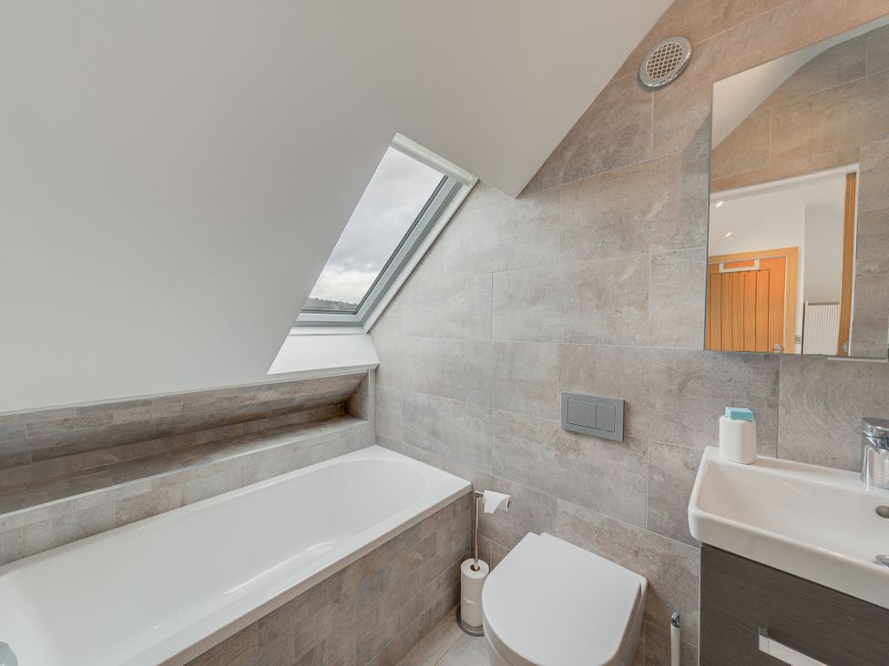 A bathroom with a bathtub, toilet, and sink at Greenacres Farm in Harriseahead near Mow Cop