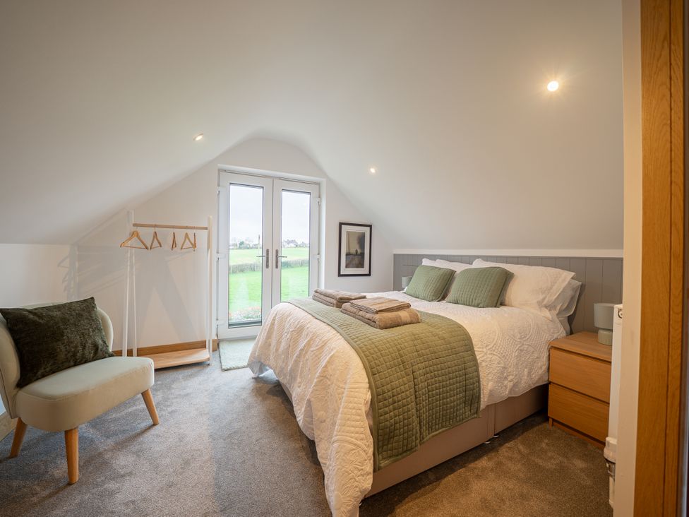 A bedroom with a bed and chair at Greenacres Farm Harriseahead near Mow Cop