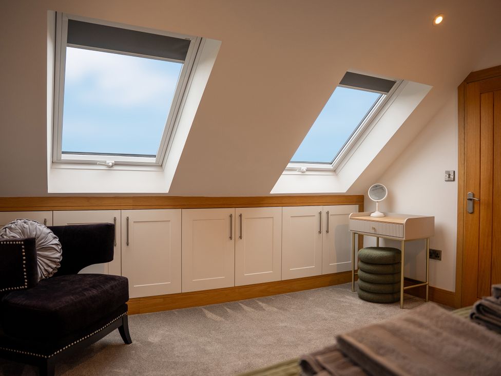 A bedroom with windows and a cabinet at Greenacres Farm in Harriseahead near Mow Cop