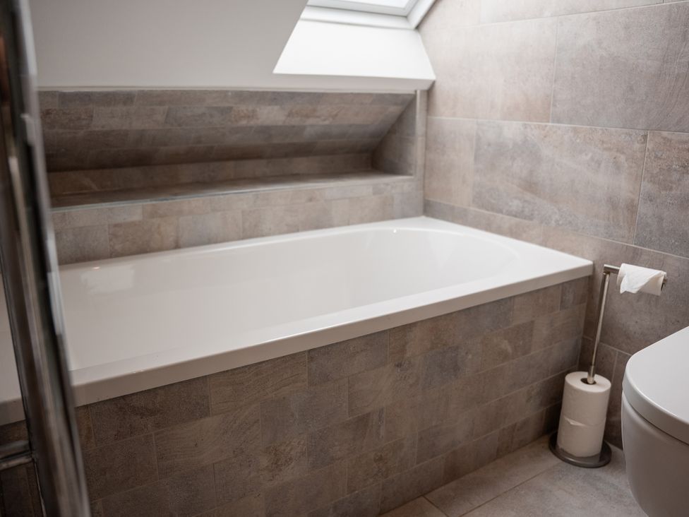 A bathroom with a bathtub and toilet at Greenacres Farm in Harriseahead near Mow Cop