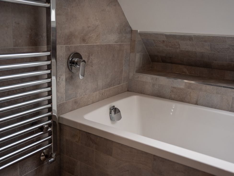 A bathroom with a bathtub and towel radiator at Greenacres Farm Harriseahead near Mow Cop