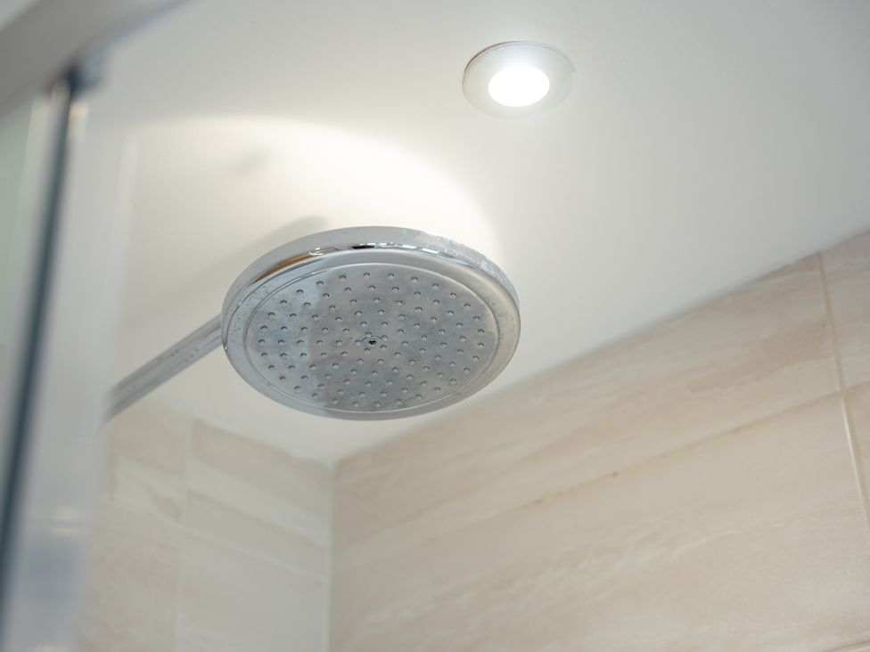 A shower head with a light fixture in a bathroom at Greenacres Farm Harriseahead near Mow Cop