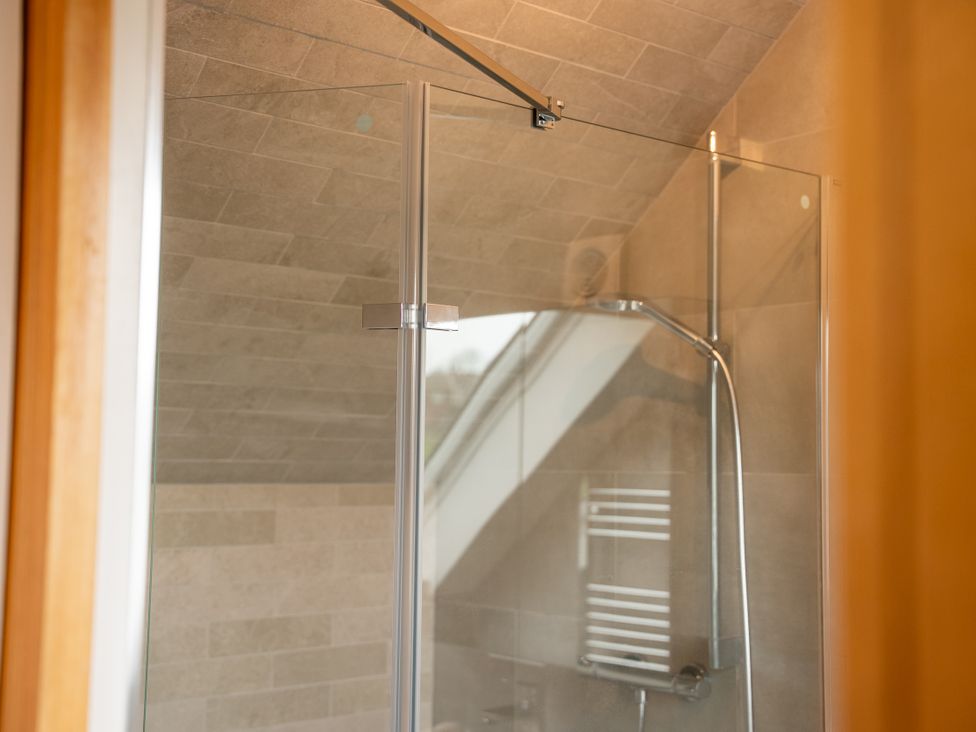 A shower area with glass door and tiled walls at Greenacres Farm near Harriseahead Mow Cop