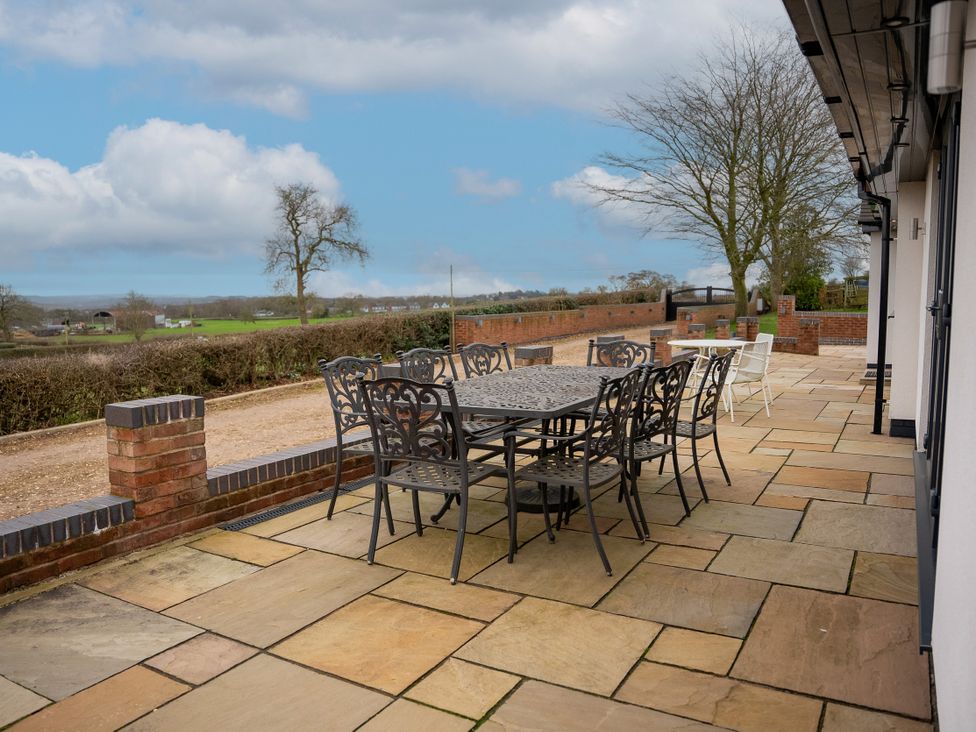 An outdoor patio with a table and chairs at Greenacres Farm in Harriseahead near Mow Cop