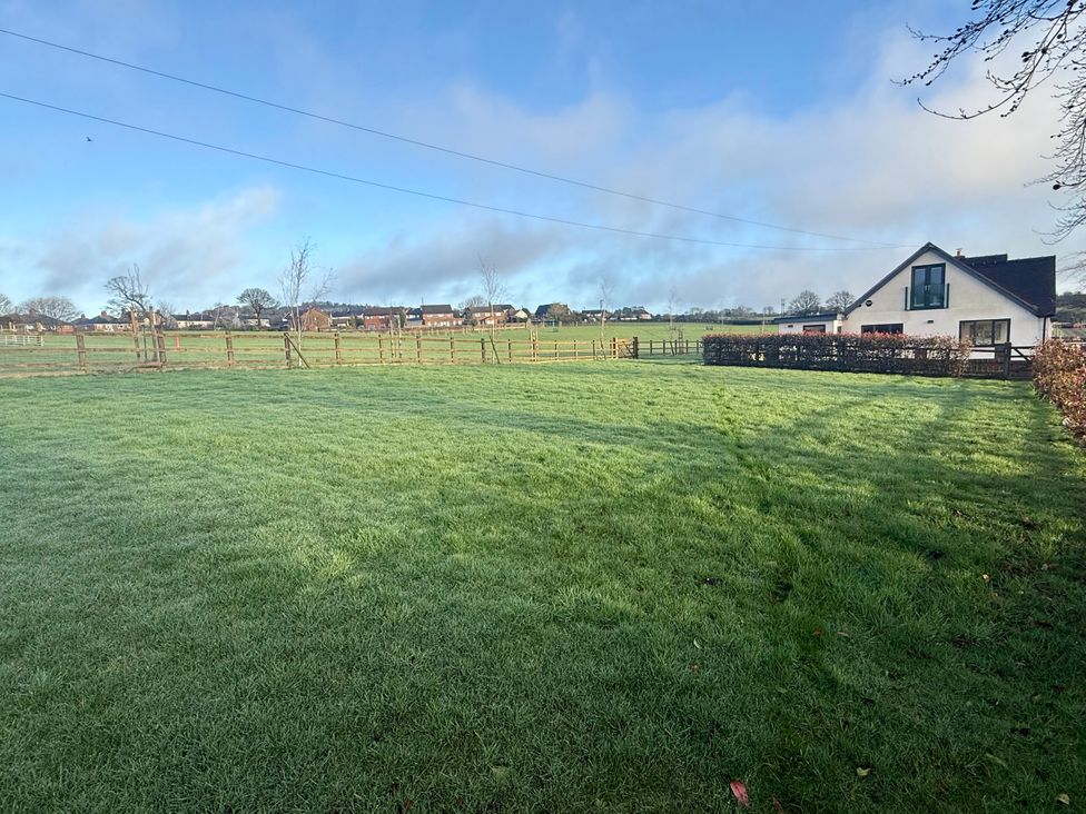 A field with a house and fence at Greenacres Farm in Harriseahead near Mow Cop