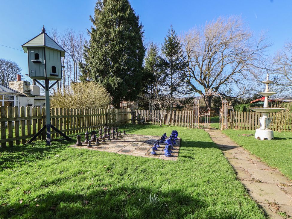 A garden with a chess set and birdhouse at The Jewel In The Crown near Biddulph Moor