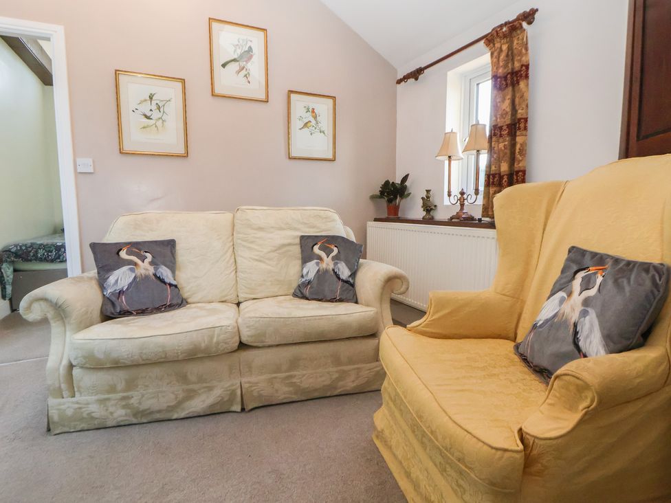 A living room with a sofa and armchair at The Jewel In The Crown near Biddulph Moor