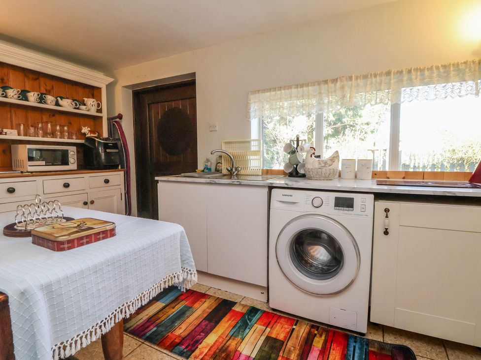 A kitchen with a washing machine and microwave at The Jewel In The Crown near Biddulph Moor