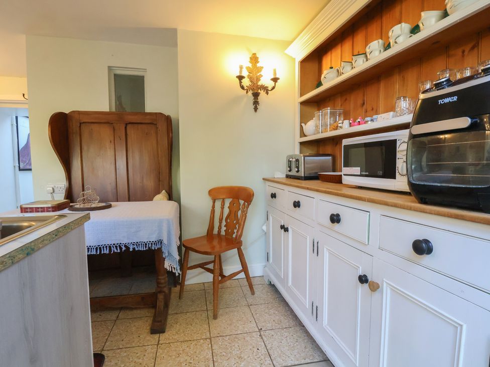 A kitchen with a dining table and appliances at The Jewel In The Crown near Biddulph Moor