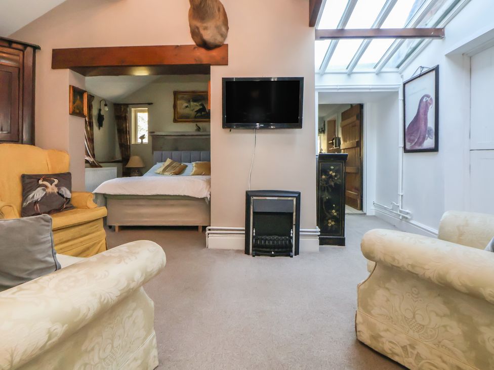 A living room with an armchair and sofa at The Jewel In The Crown near Biddulph Moor