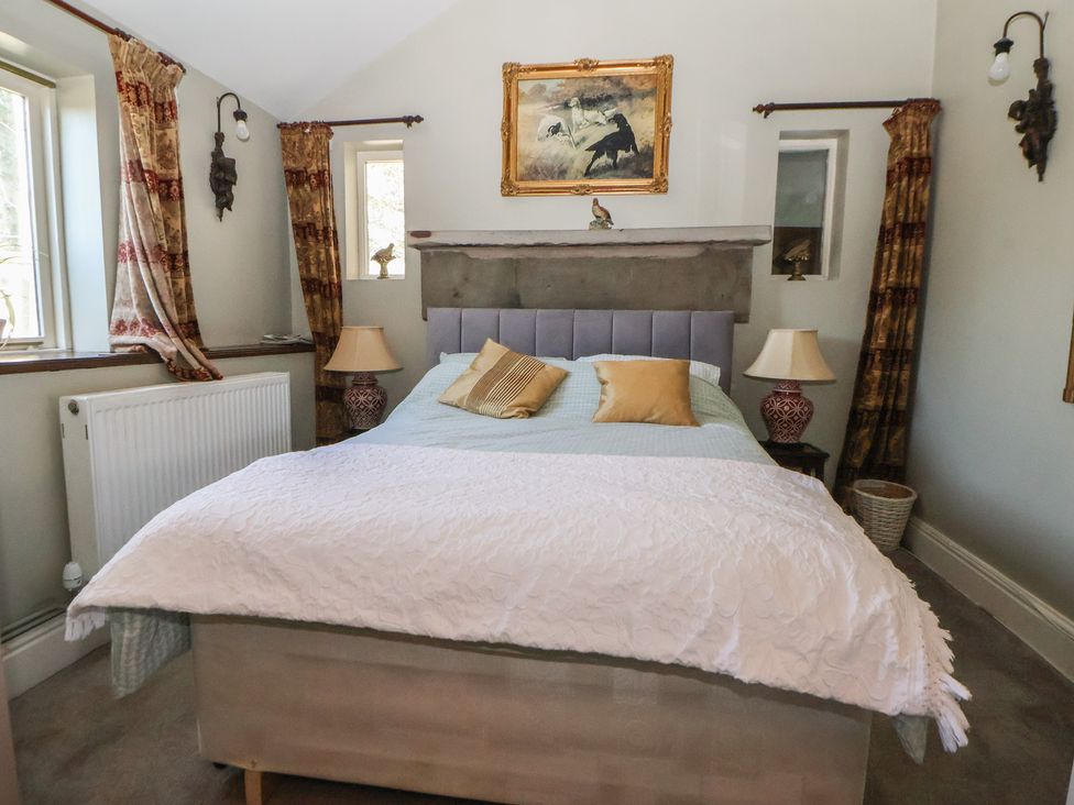 A bedroom with a bed and lamps at The Jewel In The Crown near Biddulph Moor