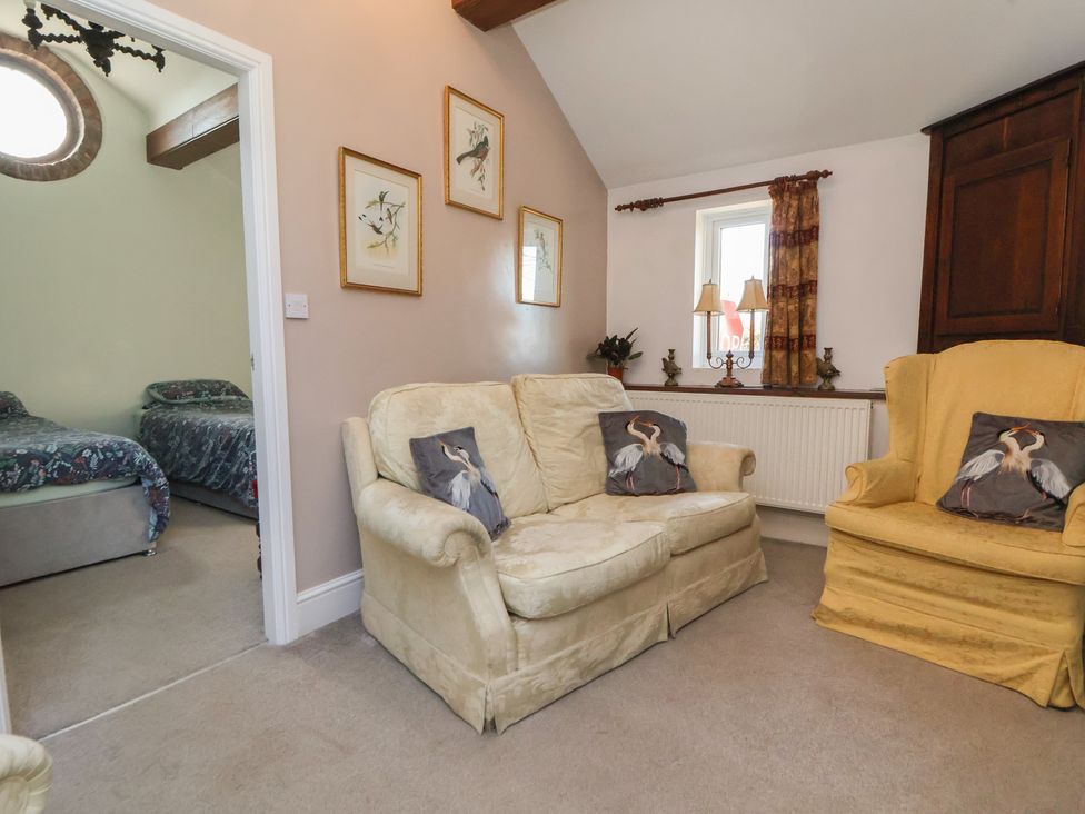 A living room with a sofa and armchair at The Jewel In The Crown near Biddulph Moor