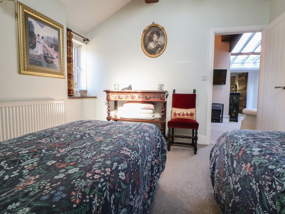 A bedroom with two beds, a chair and a table at The Jewel In The Crown near Biddulph Moor