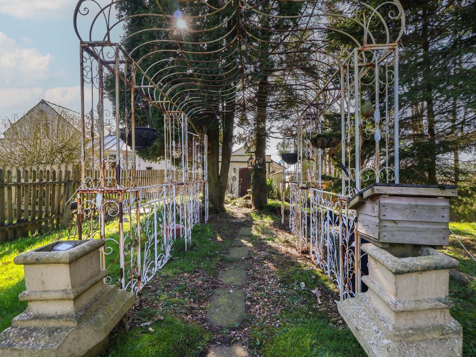 A garden pathway with trellis and planters at The Jewel In The Crown near Biddulph Moor