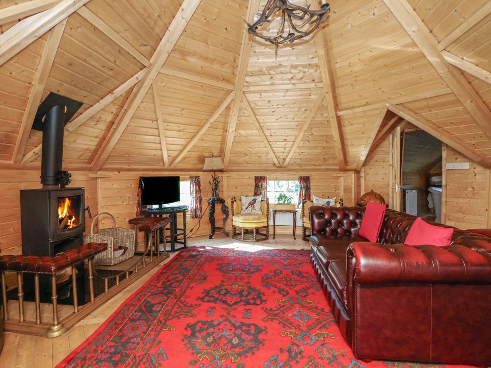 A living room with a fireplace and sofa at Antlers Lodge in Biddulph Moor