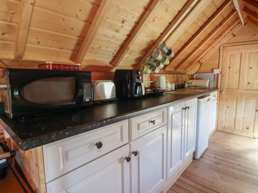 A kitchen with appliances and sink at Antlers Lodge in Biddulph Moor