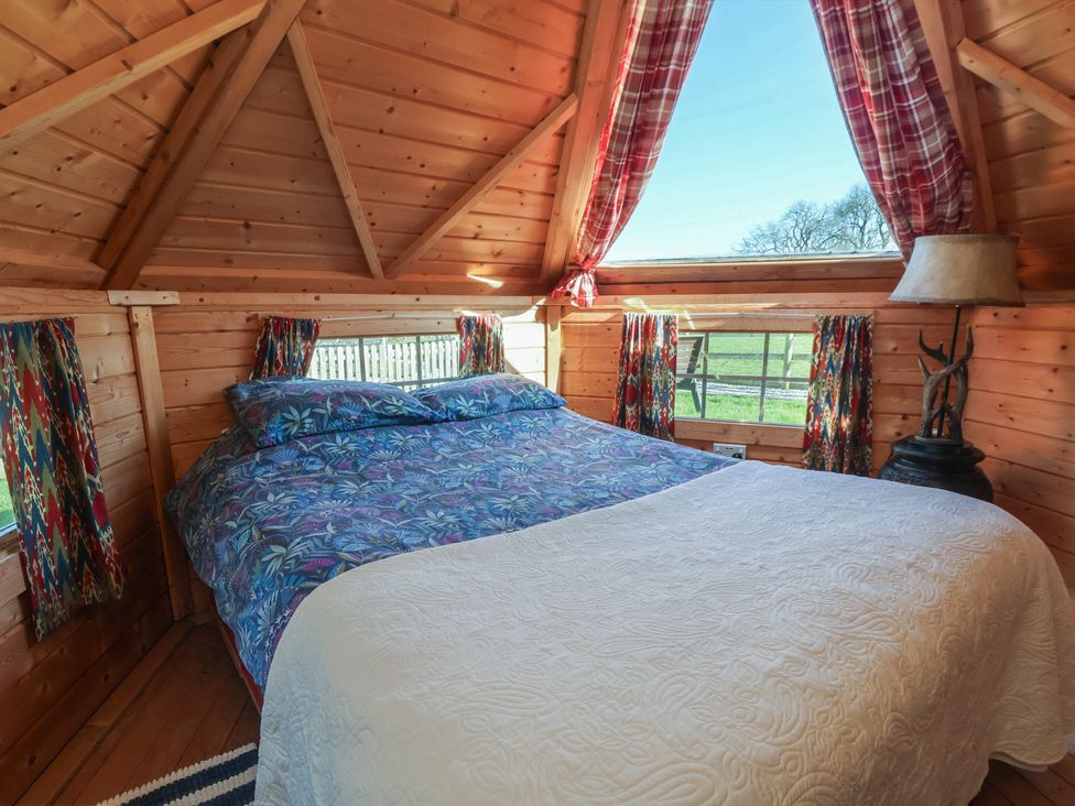 A bedroom with a bed and lamp at Antlers Lodge in Biddulph Moor