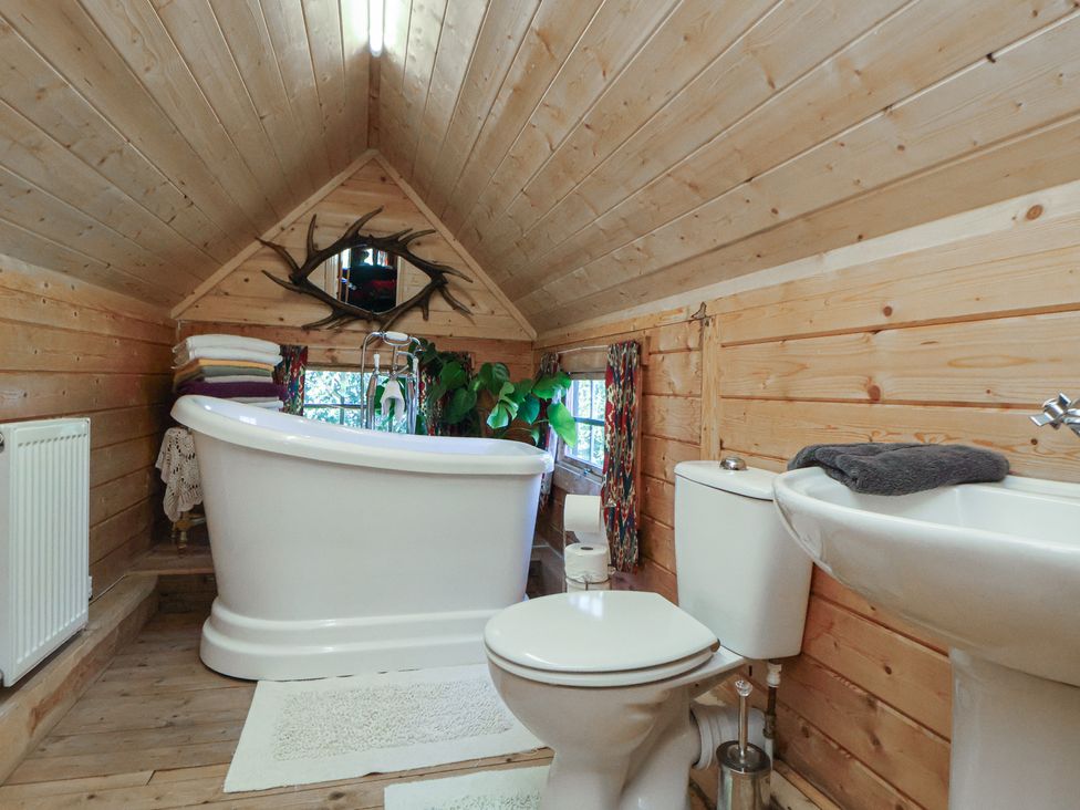 A bathroom with a bathtub, toilet, and sink at Antlers Lodge in Biddulph Moor