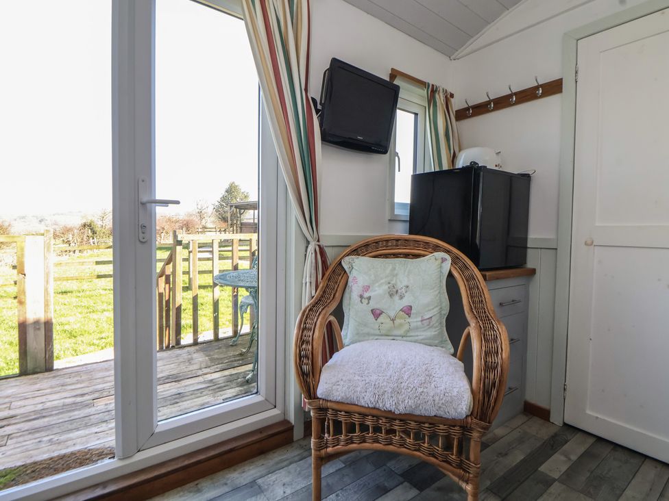 A snug with an armchair and television at Shepherds Delight in Biddulph Moor