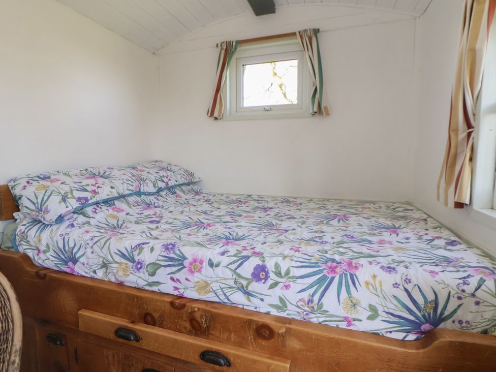 A bedroom with a bed and floral patterned sheets at Shepherds Delight in Biddulph Moor