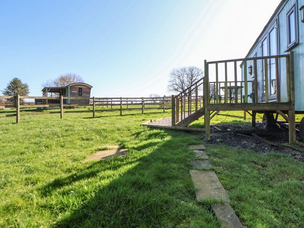 A garden with a wooden structure and fence at Shepherds Delight in Biddulph Moor