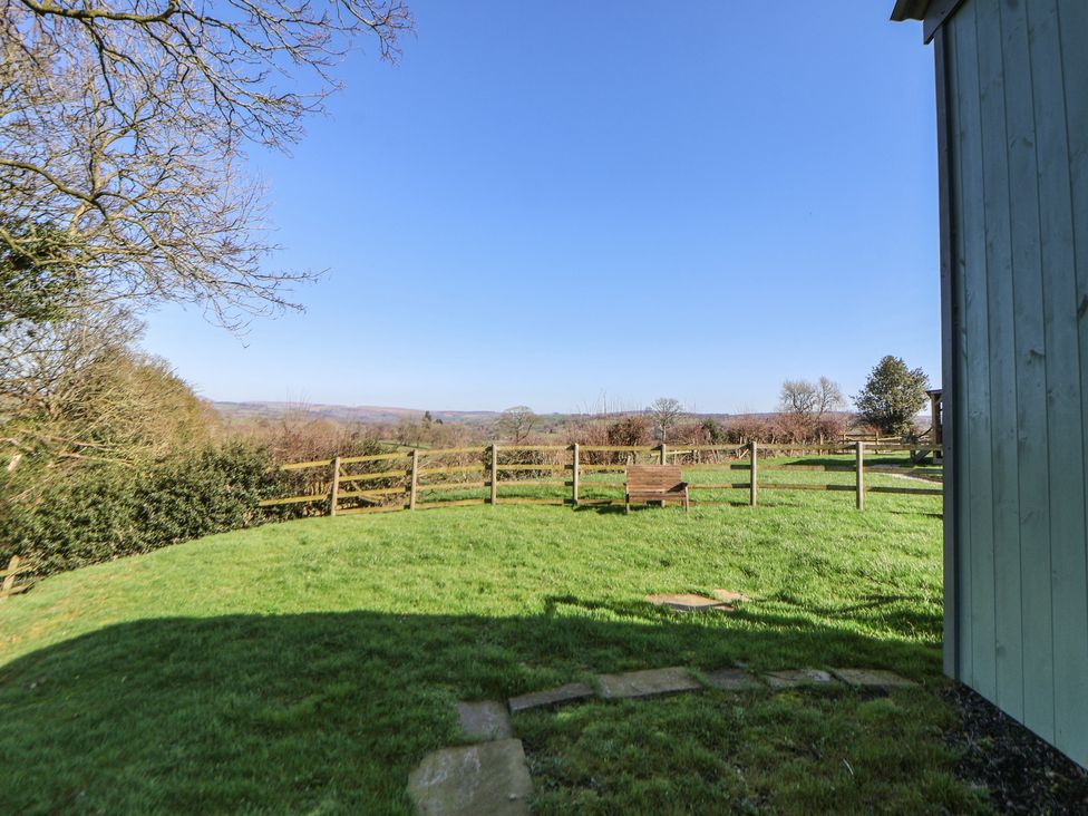 A garden with a wooden bench and a stone path at Shepherds Delight in Biddulph Moor