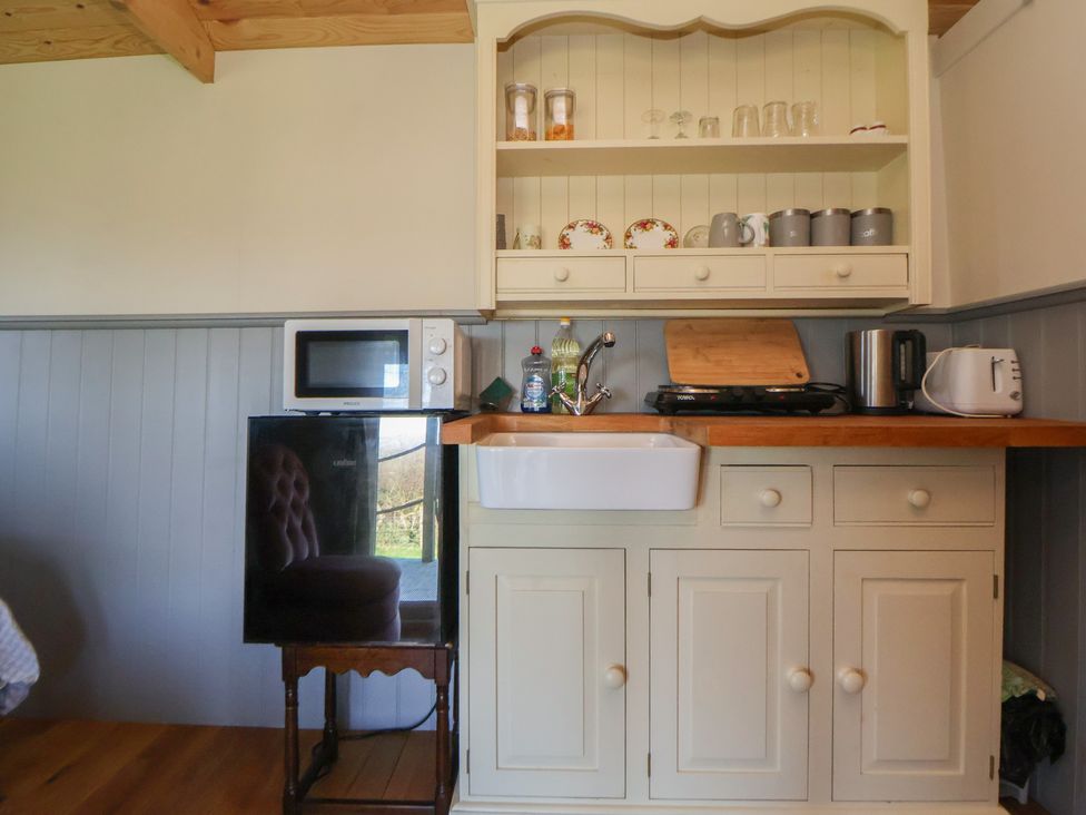 A kitchen with a sink, microwave, and refrigerator at Golden Fleece in Biddulph Moor