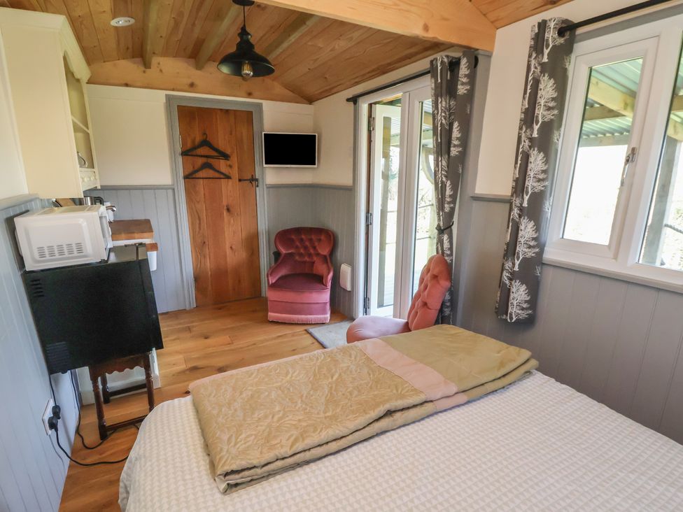 A bedroom with a bed and chair at Golden Fleece in Biddulph Moor