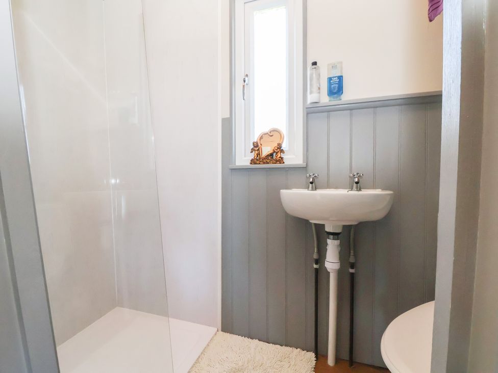 A bathroom featuring a shower, sink and window at Golden Fleece in Biddulph Moor