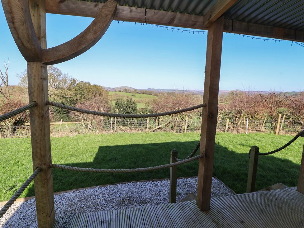 An outdoor area with a wooden structure and a view of the lawn at Golden Fleece in Biddulph Moor