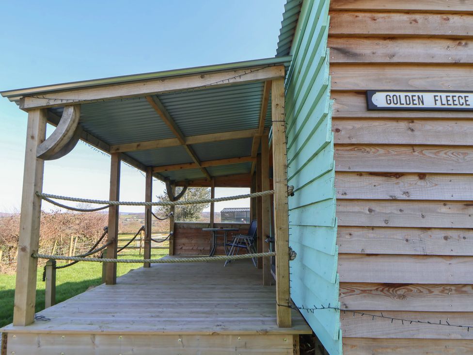 A wooden deck with chairs at Golden Fleece in Biddulph Moor