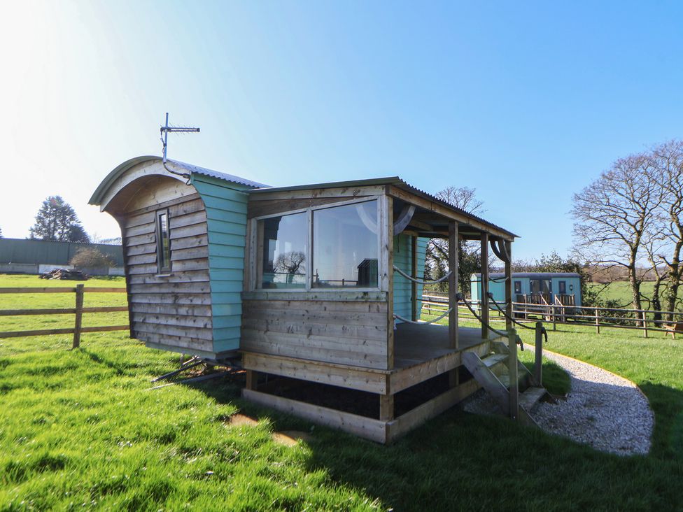 A wooden cabin with a deck and steps at Golden Fleece in Biddulph Moor