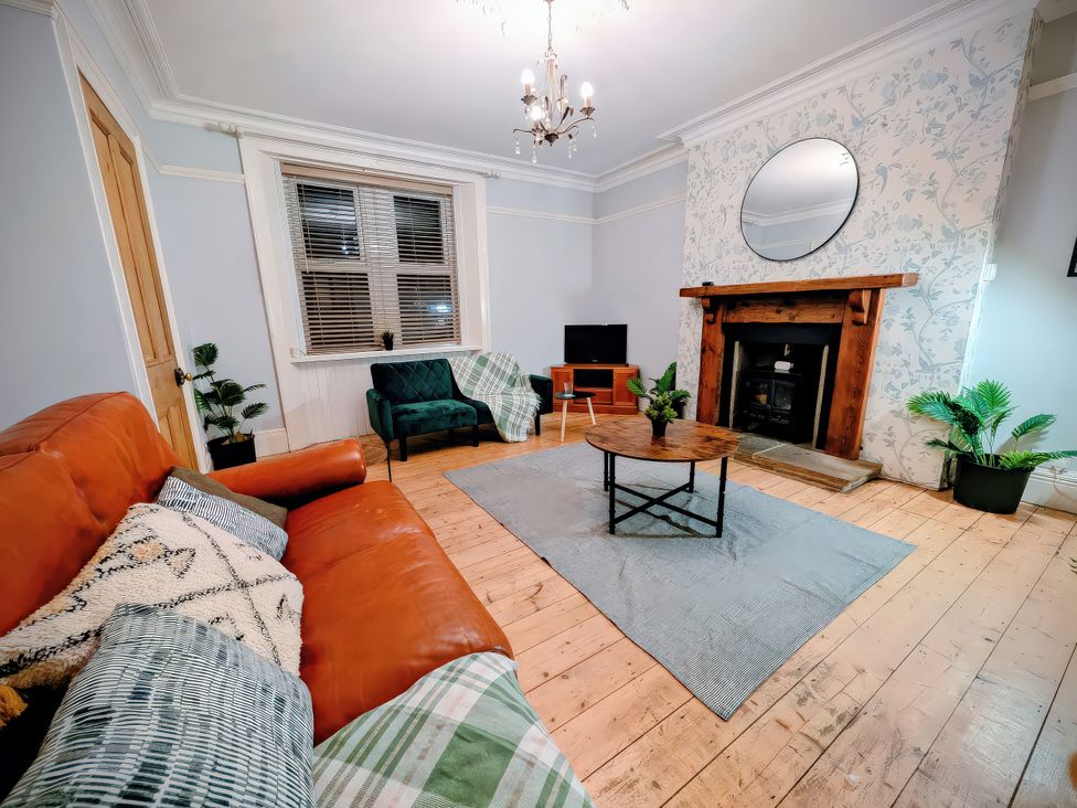 A living room with a sofa and a fireplace at 4 The Croft in Hexham