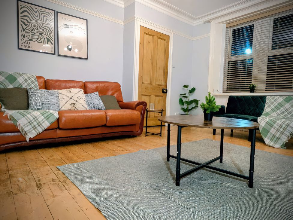 A living room with a brown sofa and a wooden table at 4 The Croft in Hexham