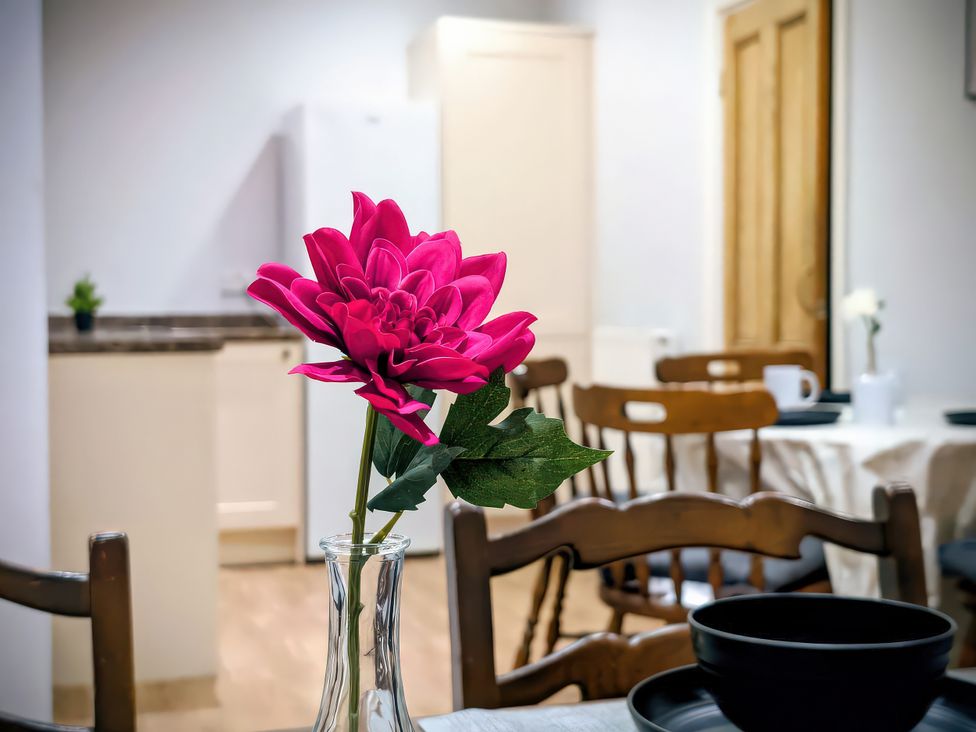 A dining room with a flower vase on a table at 4 The Croft in Hexham