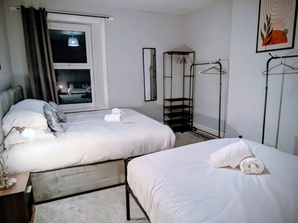 A bedroom with two beds and a window at 4 The Croft in Hexham