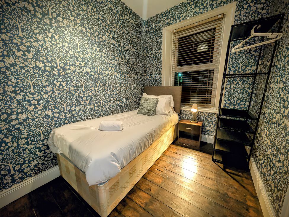 A bedroom with a bed and a shelf at 4 The Croft in Hexham