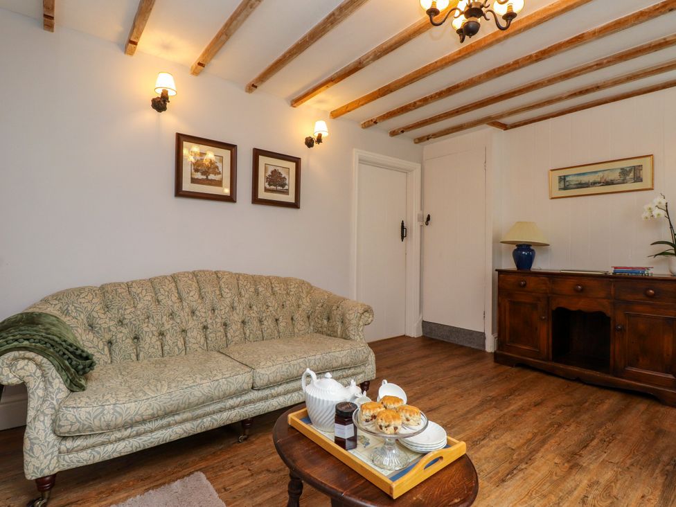 A living room with a sofa, side table, and scones at 3 Tre Felin Llandygai near Bangor