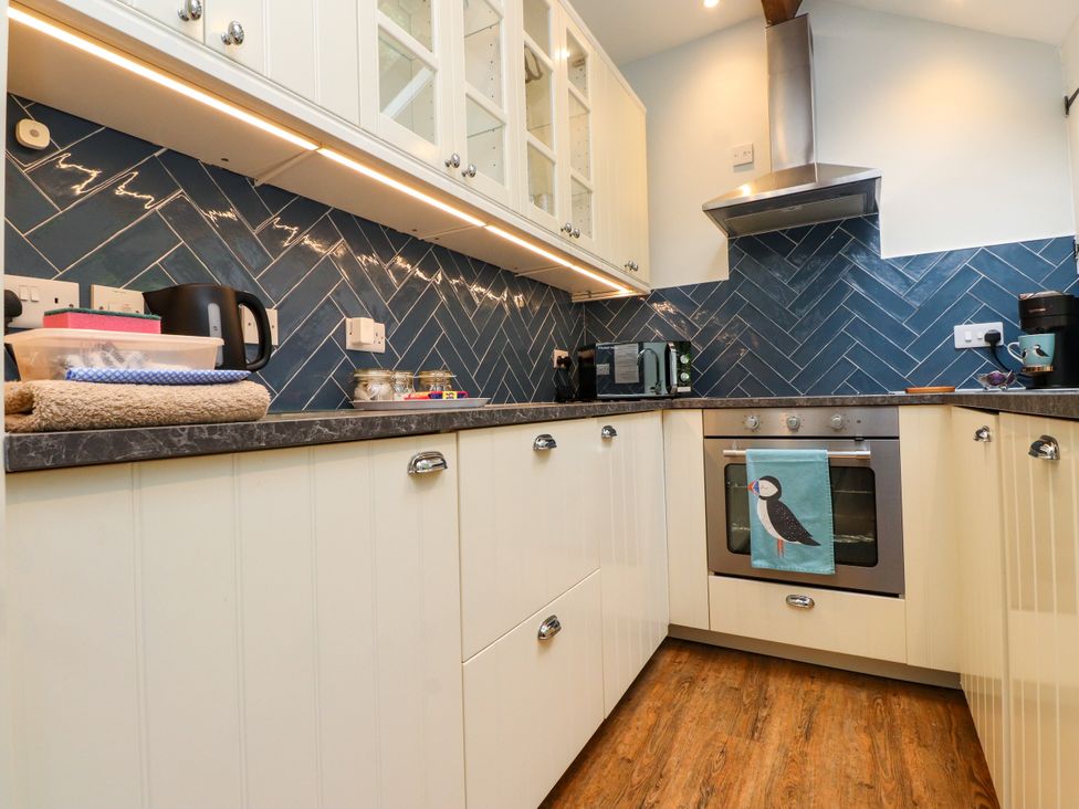 A kitchen with cabinets and appliances at 3 Tre Felin Llandygai near Bangor