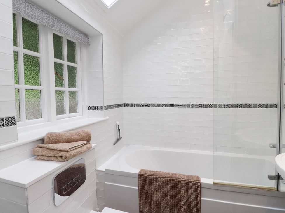 A bathroom with a bathtub and towels at 3 Tre Felin in Llandygai near Bangor
