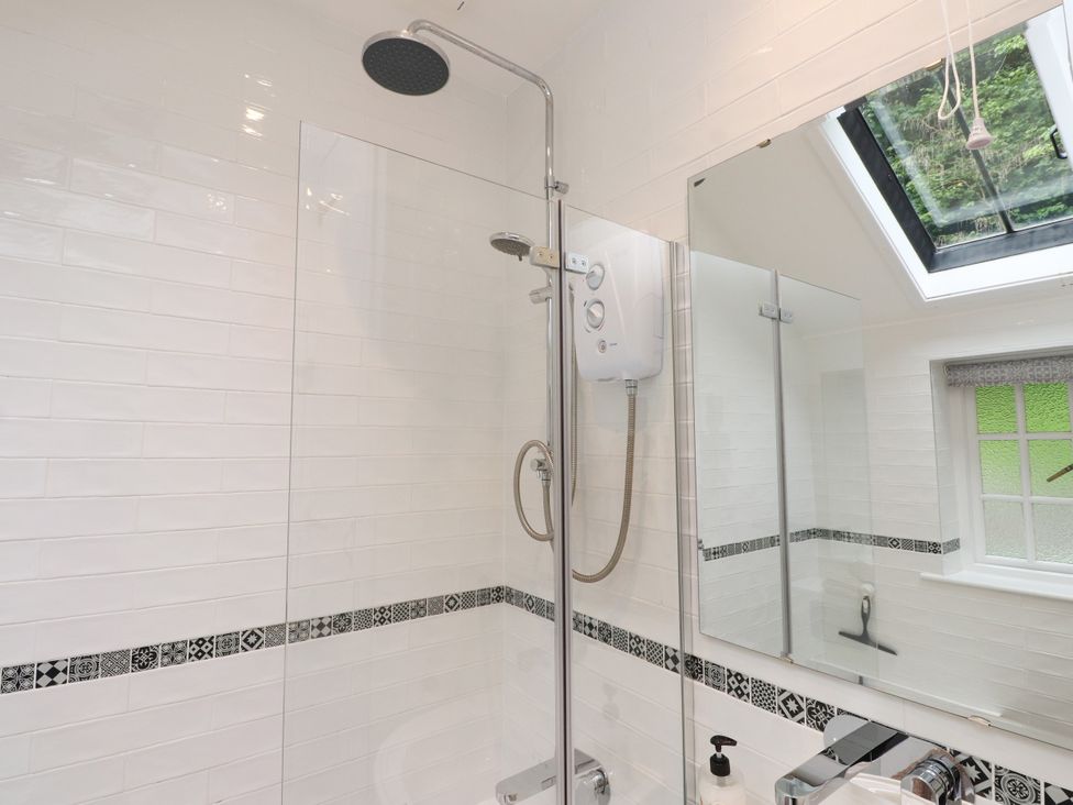 A bathroom with a shower and mirrors at 3 Tre Felin in Llandygai near Bangor