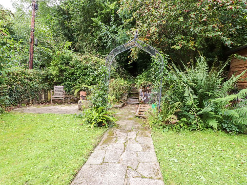 A garden with a pathway leading under an archway at 3 Tre Felin in Llandygai near Bangor