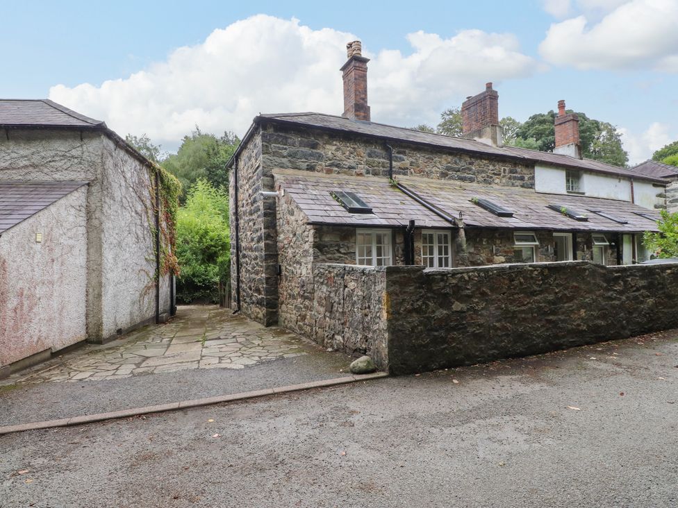 An outdoor view of a stone cottage with a path at 3 Tre Felin in Llandygai near Bangor