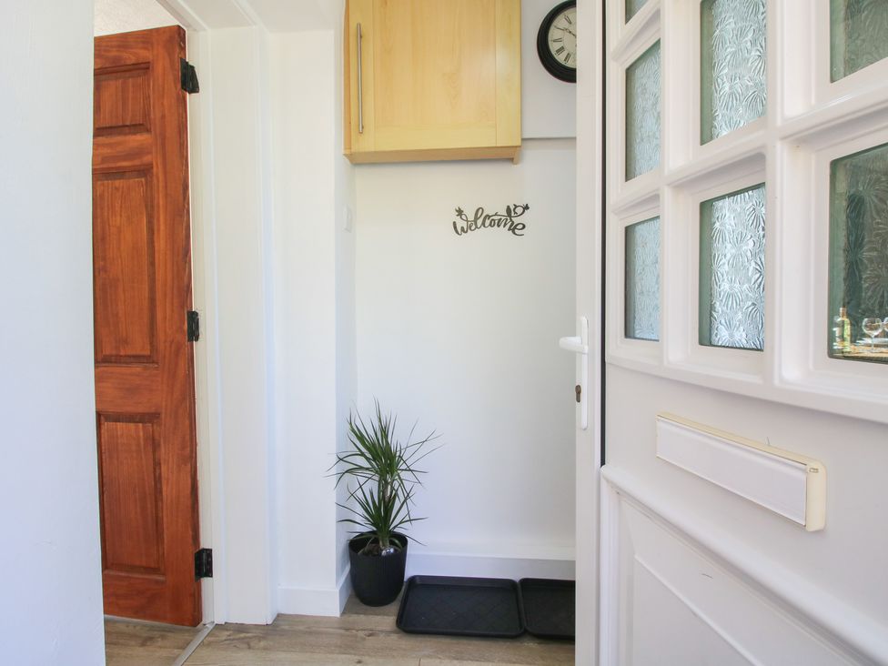A hallway with a plant and a welcome sign at Spring Bank in Llanfyllin