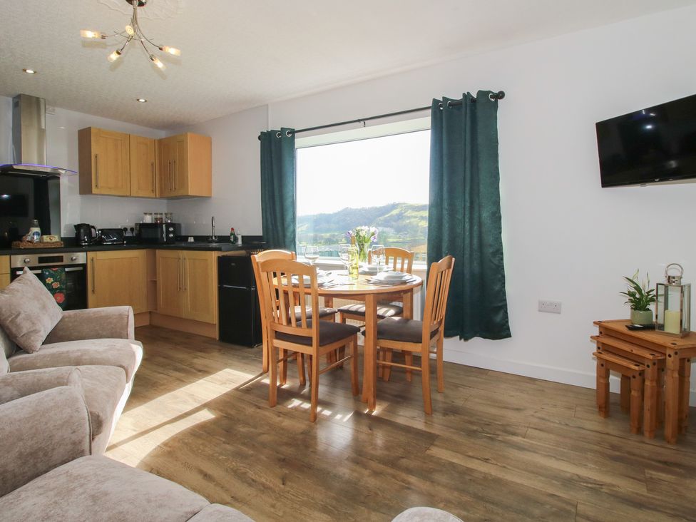 A kitchen with a dining table and chairs at Spring Bank in Llanfyllin