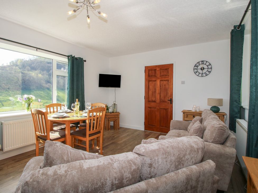 A living room with a dining area and sofa at Spring Bank in Llanfyllin