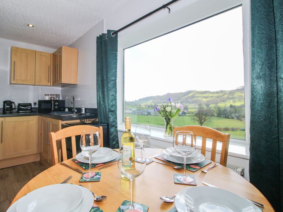 A kitchen with a table set for dining at Spring Bank in Llanfyllin