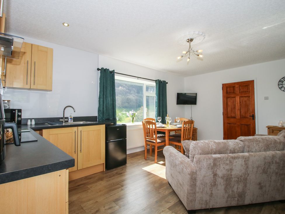 A kitchen with dining table and chairs at Spring Bank in Llanfyllin