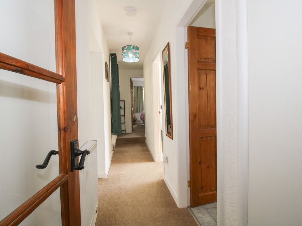 A hallway with doors and a mirror at Spring Bank in Llanfyllin