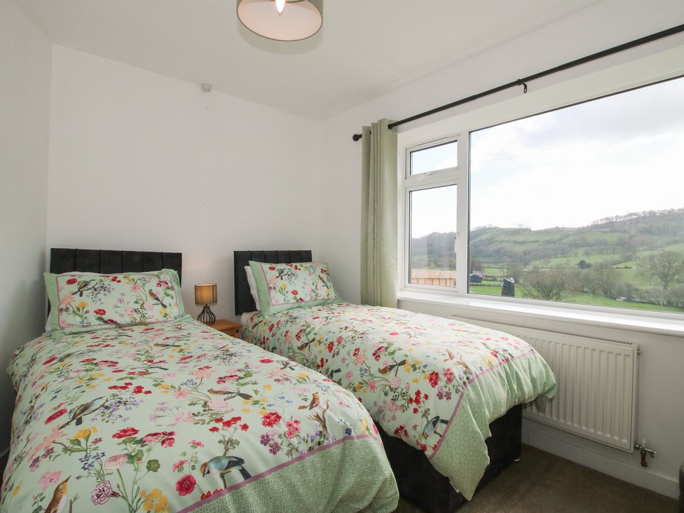 A bedroom with two beds and a view at Spring Bank in Llanfyllin